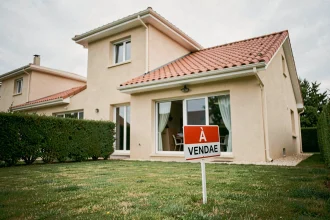 Maison à vendre avec panneau immobilier sur la pelouse lors d'une vente rapide pour cause de divorce