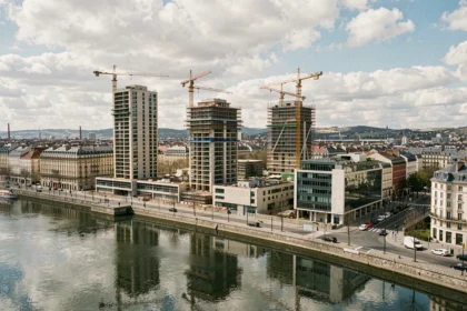 Vue panoramique sur les constructions immobilières neuves et les grues de chantier à Lyon, symbolisant le dynamisme des promoteurs immobiliers en Auvergne-Rhône-Alpes